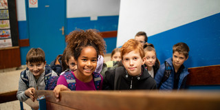 Schulkinder Mehrere Grundschulkinder laufen eine Treppe im Schulgebäude hoch.